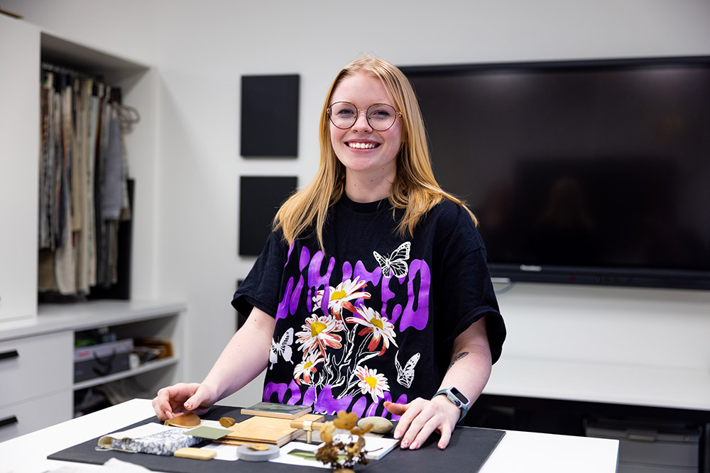 Young female student at a table with her interior design mood board.
